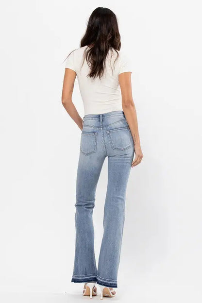 Woman from back in high rise flare jeans with raw cut hem and bottom detail