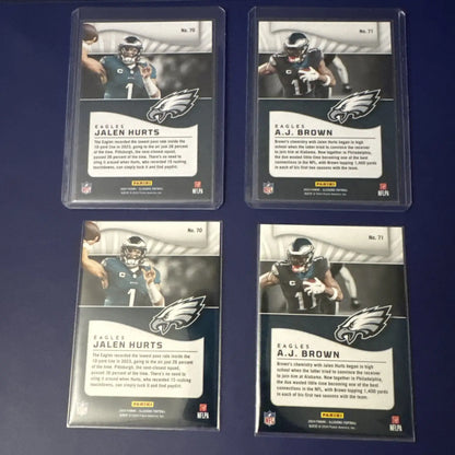 Four collectible Panini Illusions Emerald football cards featuring Jalen Hurts and A.J. Brown in protective sleeves with base color match design