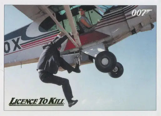 Person hanging from landing gear of small propeller plane on Gold Parallel Chase Card