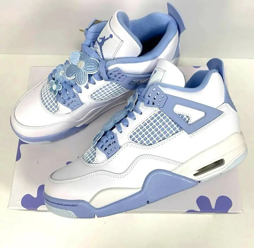 White and light blue Air Jordan 4 sneakers with flower lace accessories, fast shipping available