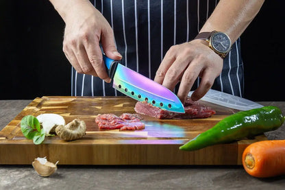 Person’s hands holding colorful iridescent kitchen knife from knife set kit over raw meat