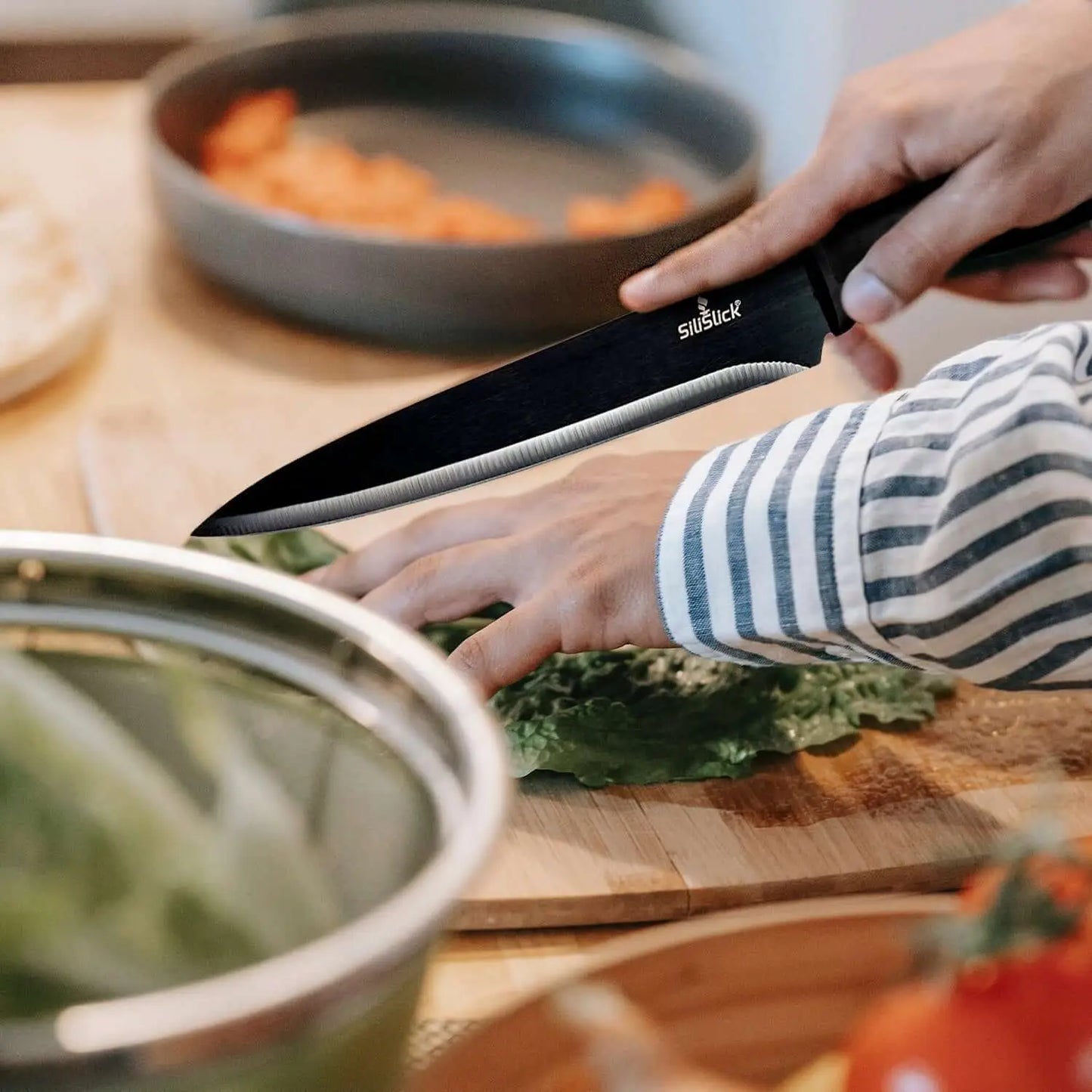 Black chef’s knife with serrated edge from Kitchen Knife Set Kit on red magnetic rack