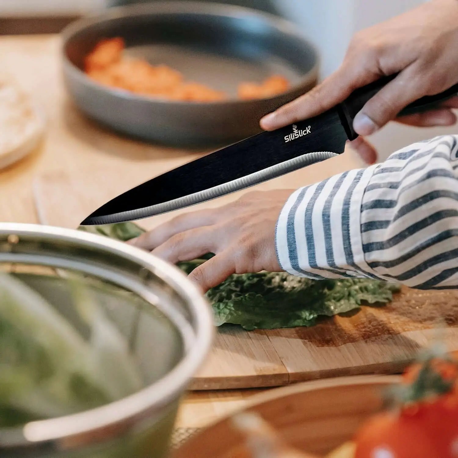 Black chef’s knife with serrated edge from Kitchen Knife Set Kit on red magnetic rack