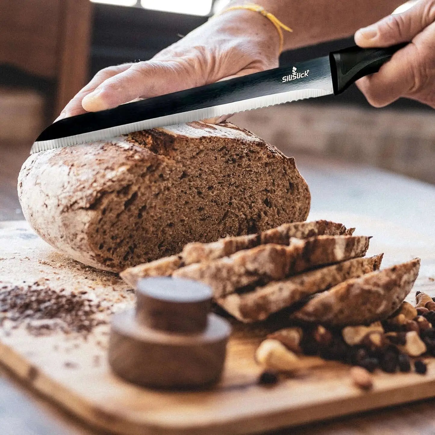 Serrated bread knife slicing rustic bread from Kitchen Knife Set Kit with red magnetic rack