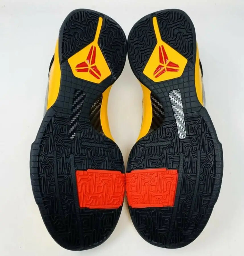 Soles of Kobe 5 Bruce Lee athletic shoes with yellow, black, red, and silver accents for fast shipping