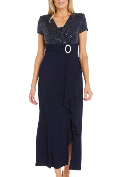 Navy blue formal maxi gown with sequined bodice, white O-ring belt, and ruffled slit