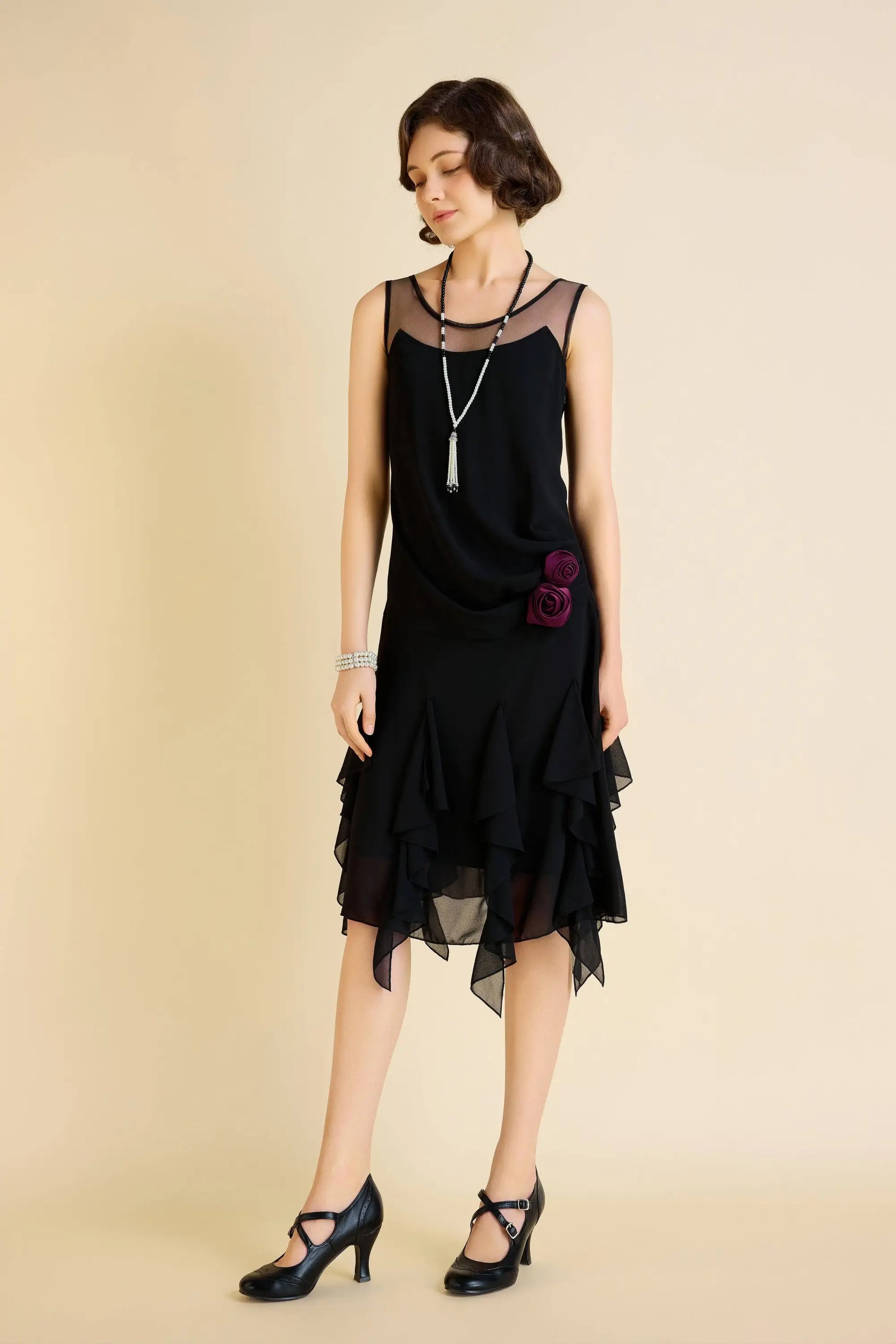 Woman modeling a black Gatsby floral ruffled day dress with sheer neckline