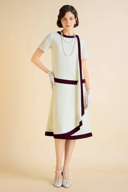 Woman in pale green Downton Abbey replica dress with draped cascading ruffles and vintage accessories