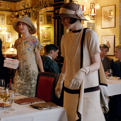 Two women in vintage downton abbey replica dresses with draped cascading ruffles