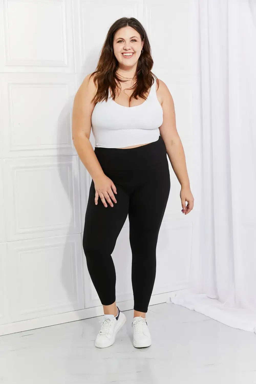 Plus-size woman wearing white crop top and black reflective dot active leggings from Leggings Depot