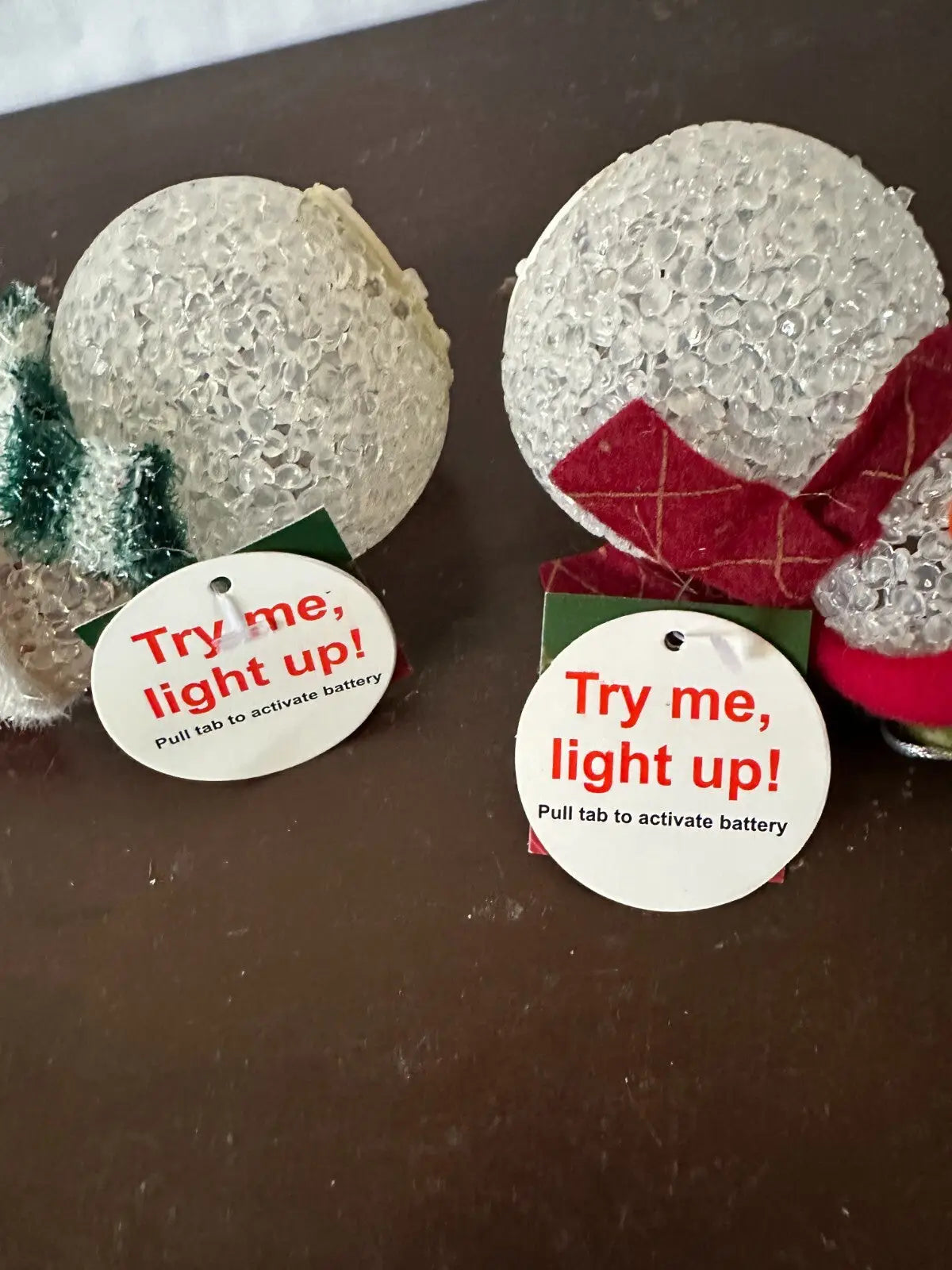 Decorative light-up snow globe-style ornaments from the Light-Up Snowman Christmas Ornaments Set for holiday decor