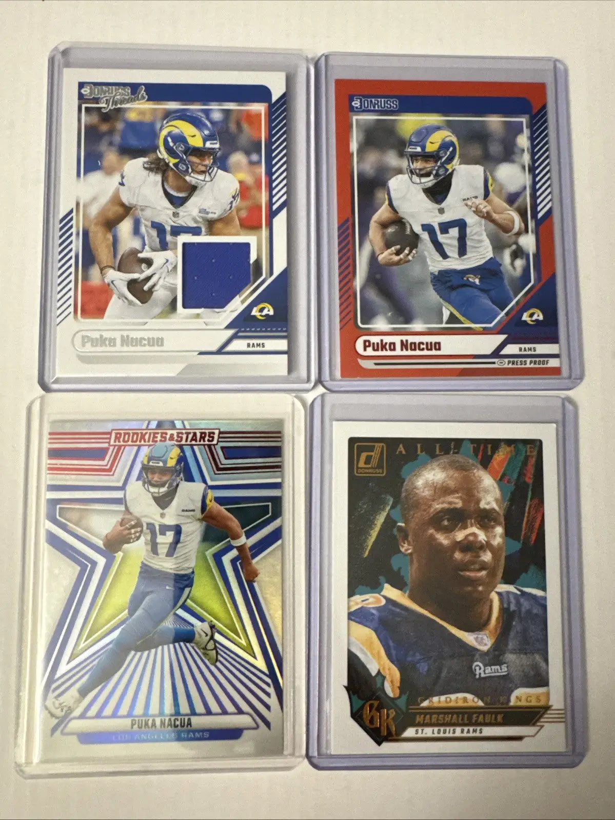 Four encased Los Angeles Rams football trading cards in a Los Angeles card lot display