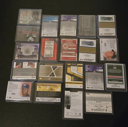 Collection of baseball trading cards in protective sleeves featuring Aaron Nola and Kyle Waldrop