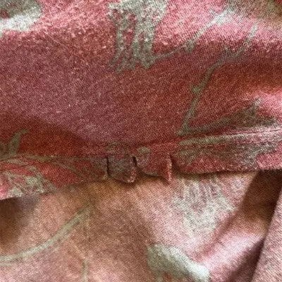 Close-up of worn marled red and grey fabric with damaged hem from Lularoe Casual Dress