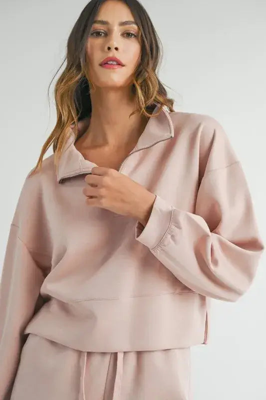 Woman modeling light pink half zip sweatshirt and matching sweatpants from Mable Apparel