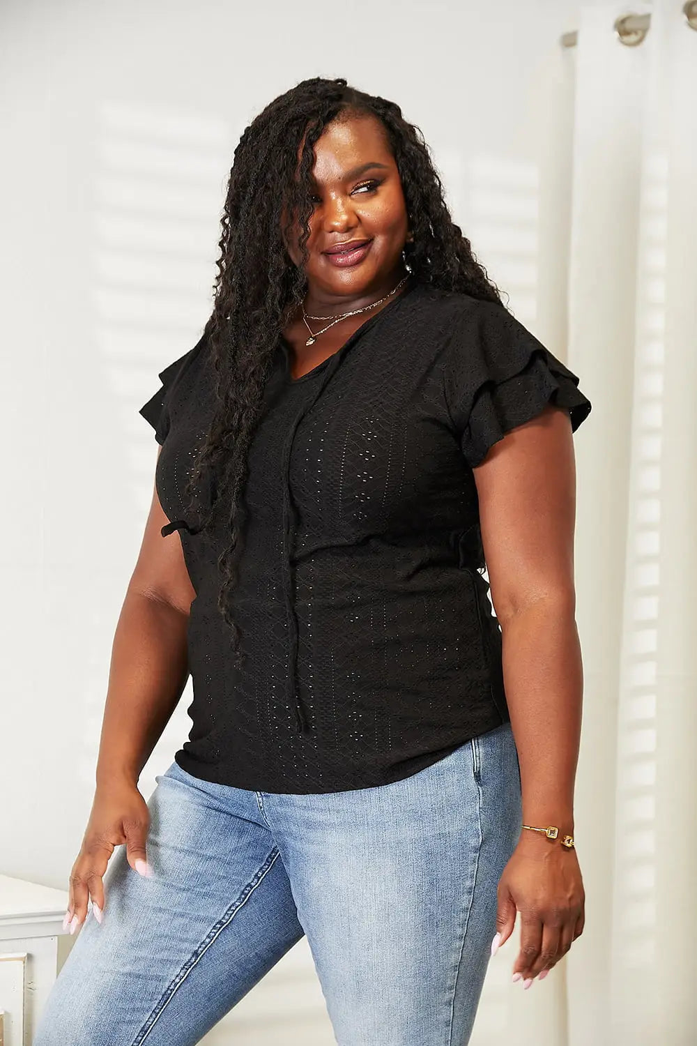 Black ruffled flutter sleeve blouse with eyelet details and button front for a stylish look