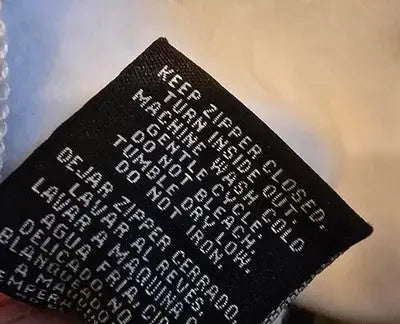 Black fabric care label with white text on Marvel Deadpool Deadpool graphic hoodie