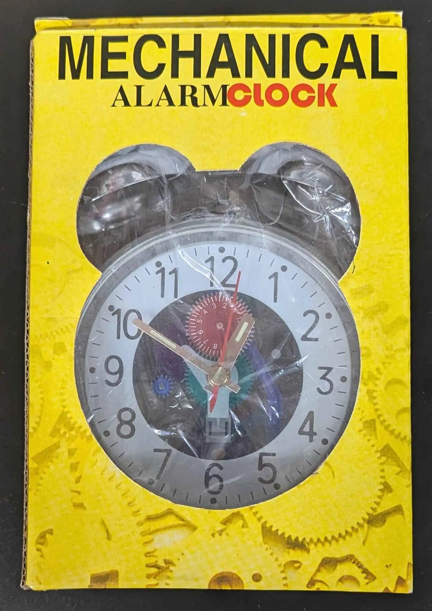 Mechanical alarm clock packaging in yellow box featuring twin-bell clock face