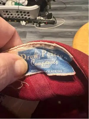 Red hat with faded blue tag from Drew Pearson Men’s Alabama Tide baseball cap with gray brim