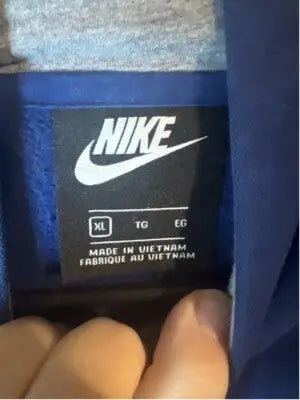 Black Nike clothing label with white text indicating XL size and made in Vietnam