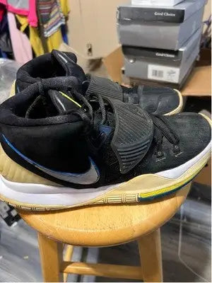 Black and blue Nike Kyrie athletic shoes with mid-top design and strap over laces