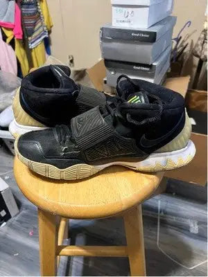Nike Kyrie athletic shoes with black design, prominent midfoot straps, and textured tan sole