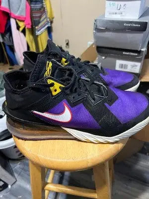 Black and purple Nike LeBron athletic shoes with white swoosh logos for men