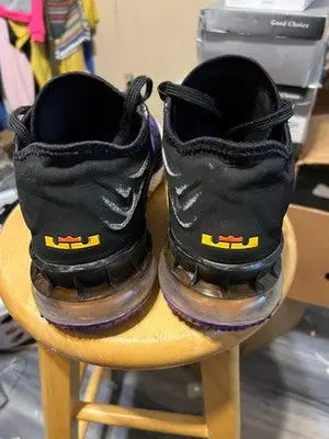 Nike LeBron athletic shoes in black with yellow logos and clear air units for men