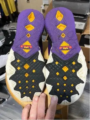 Pair of purple, black, and white Nike LeBron athletic shoe soles for men’s LeBron athletic shoes