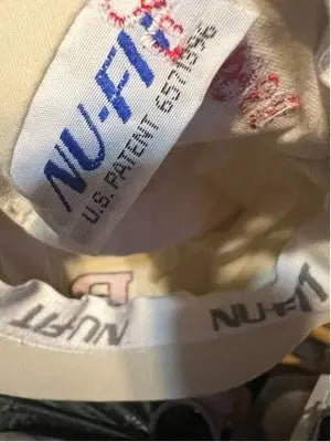 White fabric tag with blue and red embroidery on Men’s NU-FIT Rutgers R Class of 1958 beige flat cap