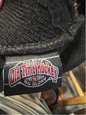 Black Old Time Hockey No Glory clothing tag on textured Philadelphia Flyers beanie with white stripe