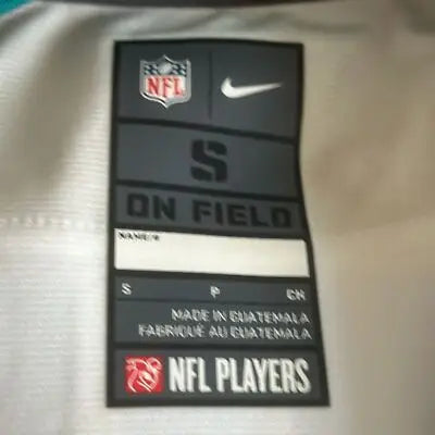 Apparel tag with size, brand, and manufacturing info on Miami Dolphins NFL Team Jersey