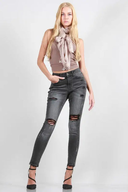Full-length of woman in beige tank top, pink scarf, black rise skinny jeans, open-toe heels