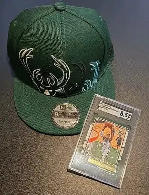 Green Milwaukee Bucks hat displayed with SGC graded Giannis Antetokounmpo card
