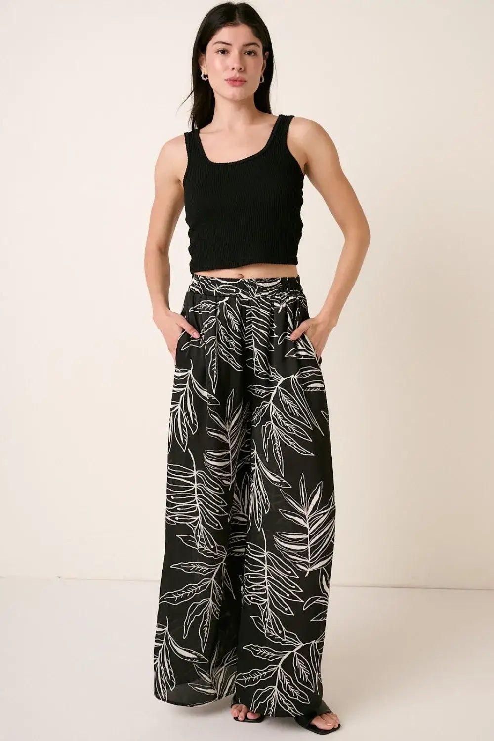 Black ribbed crop top with printed wide leg pants featuring white leaf print