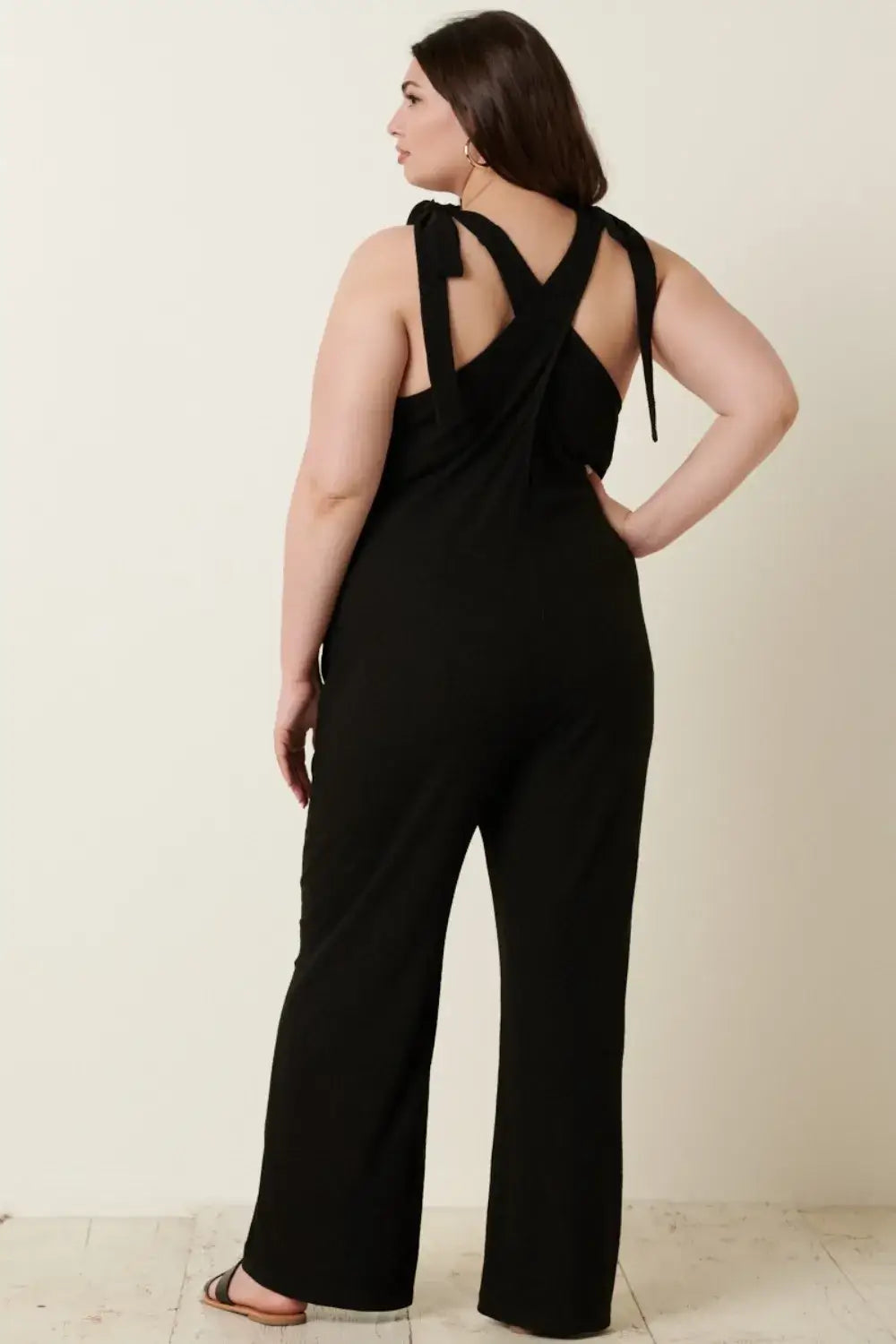 Black rib knit V-neck jumpsuit with cross-back design and wide-leg pants