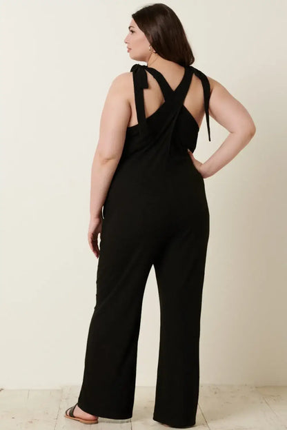 Black rib knit V-neck jumpsuit with cross-back design and wide-leg pants