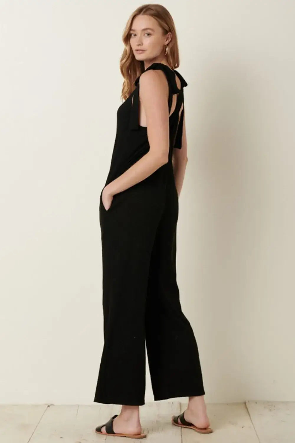 Black rib knit V-neck cross back jumpsuit with cut-out shoulders and wide-leg design