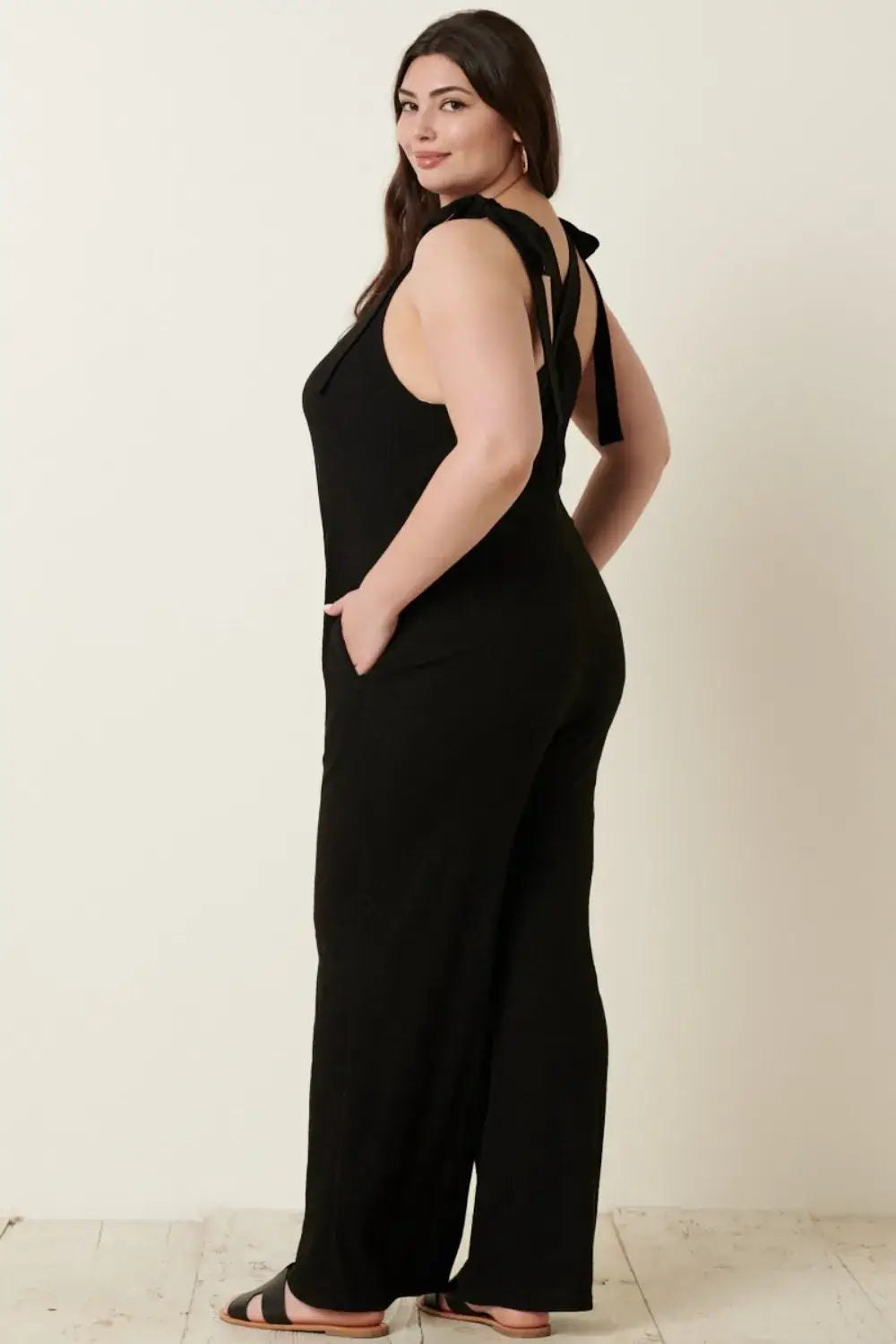 Black plus-size rib knit V-neck cross back jumpsuit with wide-leg design and thin straps