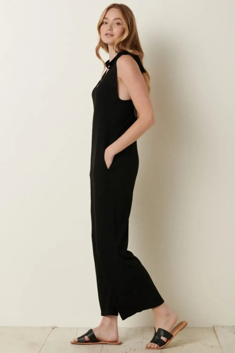 Black rib knit V-neck cross back jumpsuit with sleeveless design and flared legs