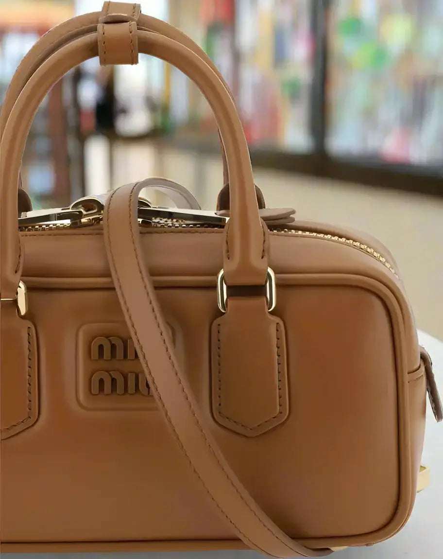 Tan leather Miu Miu Arcadie handbag with top handles and shoulder strap for luxury style