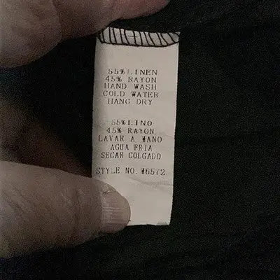 Fabric care label with material and washing instructions for Mollo Rello Women’s Black 3/4 Sleeve Dress Size Large