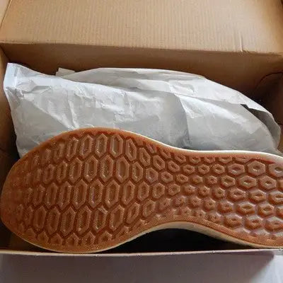 Brown rubber shoe sole with hexagonal tread pattern for New Balance Blue Athletic Sneakers