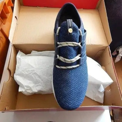 Navy blue New Balance athletic sneaker with beige laces in a brown box for men’s size 10
