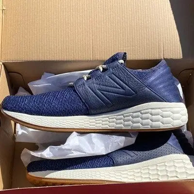 Pair of navy blue New Balance athletic sneakers with white soles for men size 10