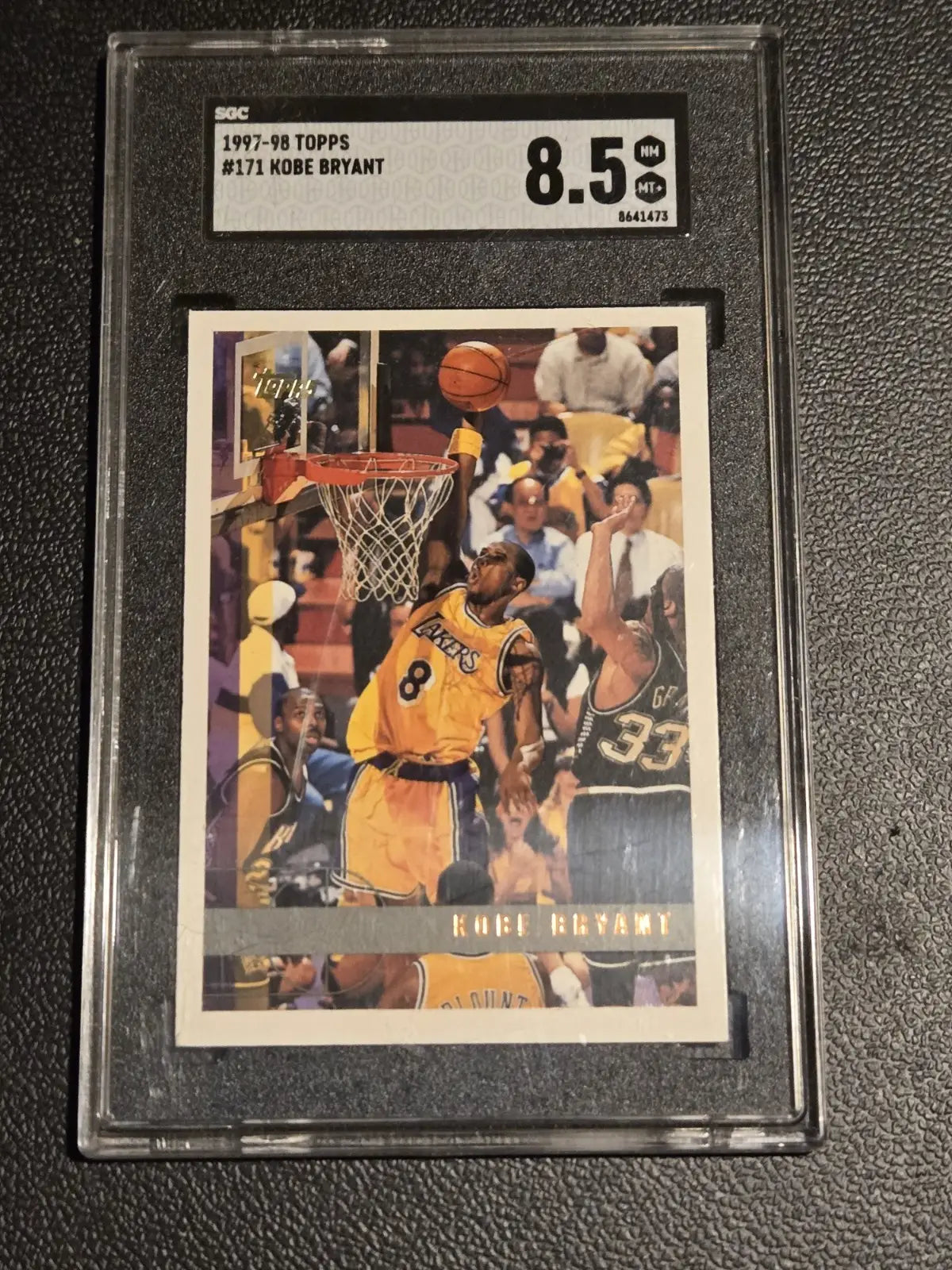 Graded Kobe Bryant basketball card with Los Angeles Lakers merchandise and New Era Lakers hat