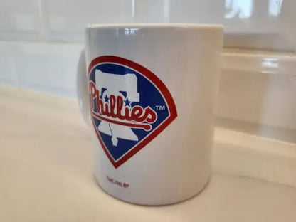 White Philadelphia Phillies ceramic coffee mug featuring the Phillies White Bell logo