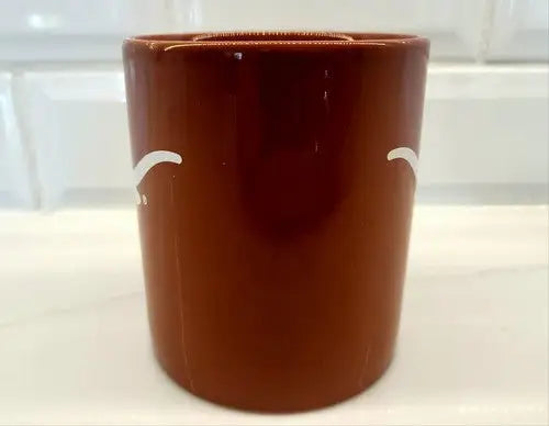 Brown ceramic toothbrush holder displayed with NCAA University of Texas Longhorns ceramic coffee mug