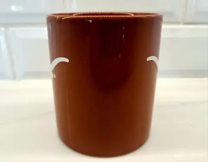 Brown ceramic toothbrush holder displayed with NCAA University of Texas Longhorns ceramic coffee mug