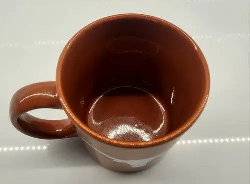 Brown ceramic coffee mug with handle featuring University of Texas Longhorns logo